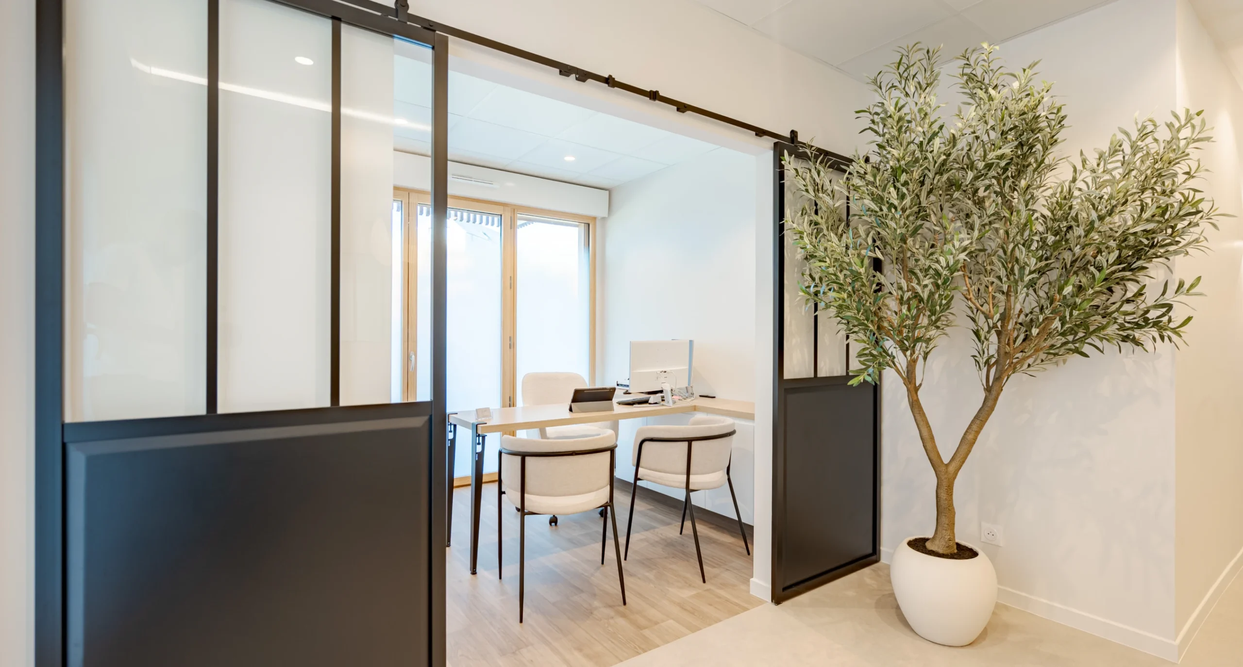 Bureau de consultation avec porte vitrée coulissante et olivier