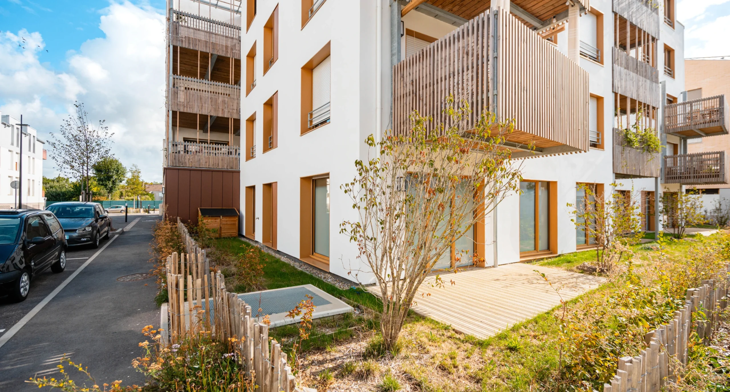 Résidence à façade en bois et son jardin, vue depuis la rue