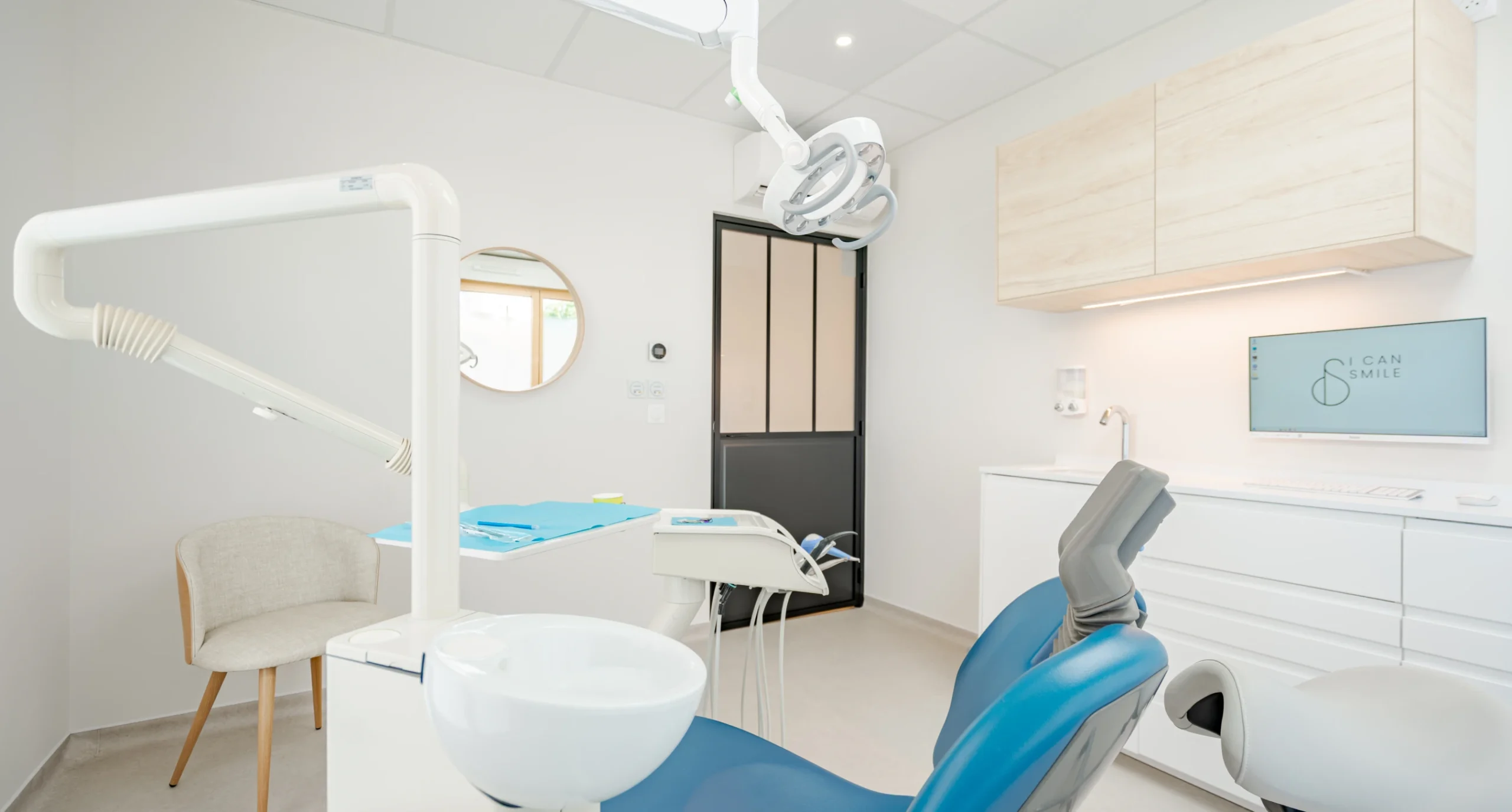 Salle de soins avec fauteuil dentaire bleu et miroir